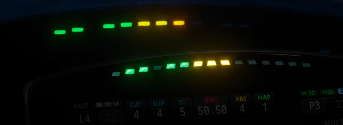 Two real rev bars of different lengths (about 10 and 15 lights) lit at the same moment, each light on at its own point from green through yellow while the rest